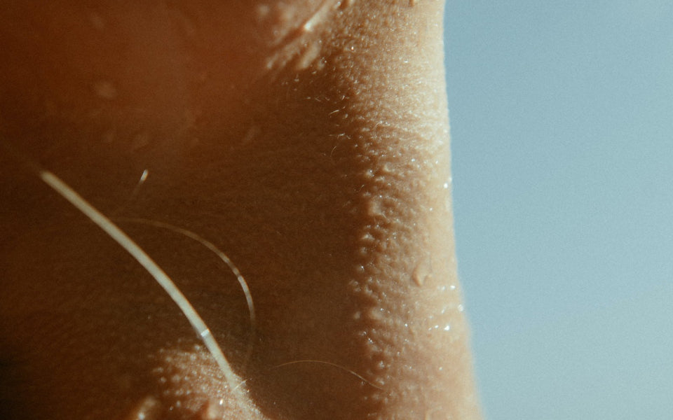 A person's neck speckled in dew